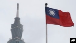 FILE - A Taiwan national flag flutters near the Taipei 101 building at the National Dr. Sun Yat-Sen Memorial Hall in Taipei, Taiwan, on May 7, 2023. 