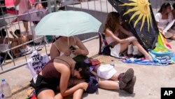 Taylor Swift fans wait for the doors of Nilton Santos Olympic stadium to open for Swift's Eras Tour concert amid a heat wave in Rio de Janeiro, Brazil, Nov. 18, 2023. The singer wound up postponing her Saturday concert after a 23-year-old fan died during her Friday show. 