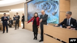 中國常駐聯合國日內瓦辦事處大使陳旭（右二）準備在聯合國人權理事會對中國人權狀況進行的定期審議會上發言前看手錶。（2024年1月23日）