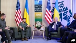 President Joe Biden listens as Ukraine's President Volodymyr Zelenskyy speaks during a meeting on the sidelines of the NATO summit in Vilnius, July 12, 2023.