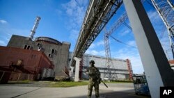 FILE - A Russian serviceman guards the Zaporizhzhia Nuclear Power Station in southeastern Ukraine, May 1, 2022. Power was restored at the plant Saturday after it was lost Friday, averting a "nuclear catastrophe," said Ukraine's energy ministry.