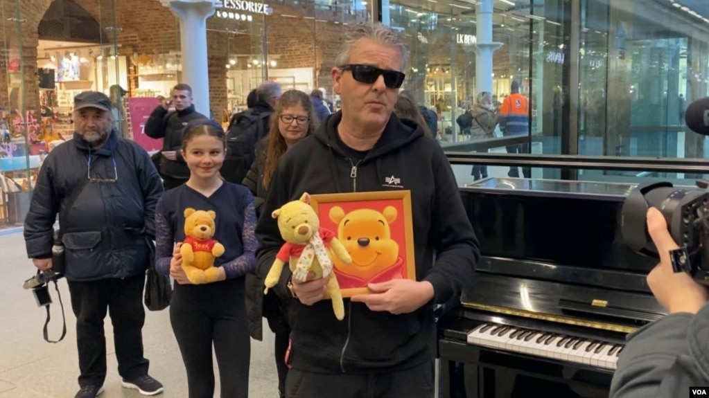 1月26日，在伦敦圣潘克拉斯国际车站，钢琴家卡瓦纳展示维尼熊玩偶和画像 (美国之音/李伯安)(photo:VOA)