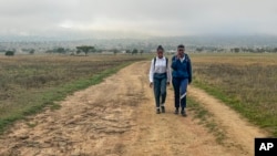 Luyanda Hlali, left, and her friend Mimi Dubazane embark on their routine 2 hour-long walk from the village of Stratford to their school in Dundee, South Africa, Thursday, Oct. 26, 2023. (AP Photo/ Mogomotsi Magome)
