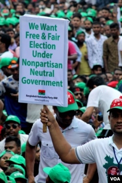 A demonstrator holds a poster at the BNP protest rally in Dhaka, Bangladesh, July 12, 2023, calling for a free and fair election. (Babul Talukdar for VOA)