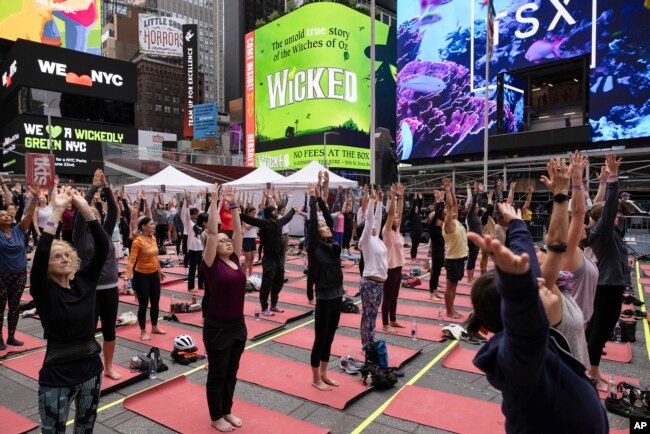 People participate in a yoga class during the "Times Square: Mind Over Madness Yoga" event, to celebrate the summer solstice June. 21, 2023, in New York. (AP Photo/Yuki Iwamura)