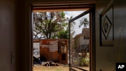 FILE - The burnt house next to Daniel Skousen's home is seen from Skusen's front door on Nov. 3, 2023, in Lahaina, Hawaii.