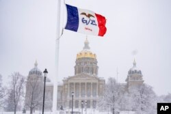 FILE - Snow falls at the Iowa State Capitol Building in Des Moines, Iowa, Jan. 9, 2024, as a winter snow storm hits the state.