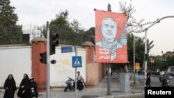 Orang-orang berjalan melewati spanduk bergambar mendiang pemimpin Hamas Ismail Haniyeh di sebuah jalan di Teheran, Iran, 12 Agustus 2024. (Majid Asgaripour/WANA (West Asia News Agency) via REUTERS)