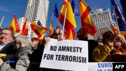 Protestors hold signs and wave Spanish flags during a demonstration called by the opposition party Partido Popular (PP) against the government's amnesty law, on the Plaza de Espana square in Madrid, Jan. 28, 2024.