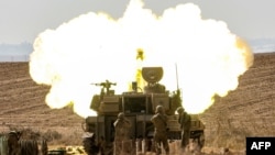 An Israeli army self-propelled howitzer fires rounds near the border with Gaza in southern Israel, Oct. 11, 2023.