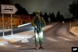 An Israeli soldier stands guard the near the scene of a car that exploded in the West Bank settlement of Karme Tsur, Aug. 31, 2024.