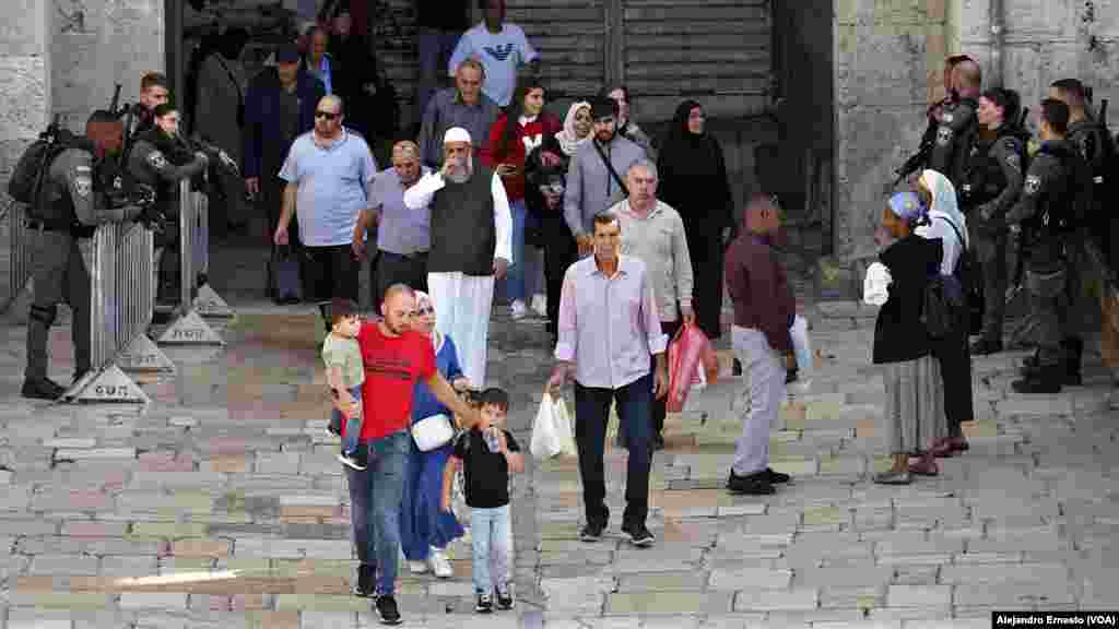 Varios palestinos salen de la Ciudad Vieja de Jerusalén por la Puerta de Damasco, fuertemente custodiada hoy por la policía de fronteras de Israel.