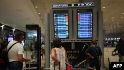 Penumpang melihat papan keberangkatan di Bandara Ben Gurion dekat Tel Aviv, Israel, pada 7 Oktober 2023, ketika penerbangan dibatalkan karena serangan mendadak Hamas. (Foto: AFP)