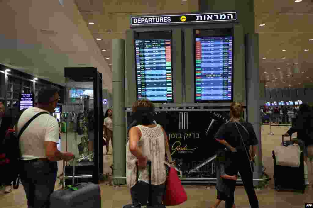 Passengers look at a departure board at Ben Gurion Airport near Tel Aviv, Israel, Oct. 7, 2023, as flights are canceled because of the Hamas surprise attacks.