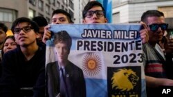 Simpatizantes sostienen una pancarta del candidato presidencial de la oposición Javier Milei afuera de su sede de campaña después del cierre de las urnas en la segunda vuelta presidencial en Buenos Aires, Argentina, el domingo 19 de noviembre de 2023. (Foto AP/Natacha Pisarenko)