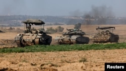 Kendaraan militer Israel bermanuver di dekat perbatasan Israel setelah meninggalkan Gaza, selama gencatan senjata sementara antara Hamas dan Israel, di Israel, 24 November 2023. (Foto: REUTERS/Amir Cohen)
