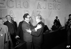 FILE - U.S. Secretary of State Henry Kissinger, left, embraces Argentine foreign minister Alberto J. Vignes as they say goodbye at the end of the Latin foreign ministers conference in Mexico City, Feb. 23, 1974.