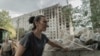 A resident cleans debris around a heavily damaged residential building following a recent missile attack in Kharkiv, on Aug. 31, 2024.