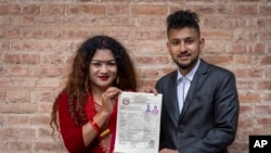 Same-sex couple Surendra Pandey, right, and Maya Gurung, who got married six years ago, pose for a photograph with their marriage certificate in Kathmandu, Nepal, Dec. 1, 2023.