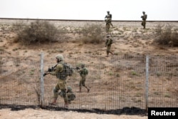 以色列士兵冒着加沙的火箭袭击在以色列斯德洛特附近地区搜索哈马斯武装分子。（2023年10月9日）