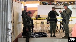 Military personnel stand guard at the entrance of a gymnasium while police investigators look for evidence after a bomb attack at Mindanao State University in Marawi, Lanao del sur province, Philippines, Dec. 3, 2023. 