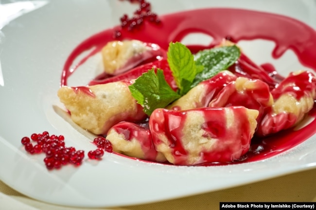 FILE - Ukrainian varenyky with cherries in a white plate of white tablecloth. (Adobe Stock Photo by Ismishko)