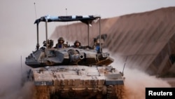 A tank maneuvres near the Israel-Gaza border fence before entering Gaza, amid the ongoing conflict between Israel and the Palestinian Islamist group Hamas, as seen from southern Israel, March 3, 2024.