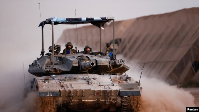 A tank maneuvres near the Israel-Gaza border fence before entering Gaza, amid the ongoing conflict between Israel and the Palestinian Islamist group Hamas, as seen from southern Israel, March 3, 2024.