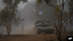 Israeli army tanks move along the Gaza Strip border, in southern Israel, Dec. 11, 2023.