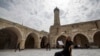 غزہ کی قدیم، ’’عمری جامعہ مسجد‘‘ میں ایک فلسطینی قرآن پڑھ رہا ہے، 23 مارچ، 2023۔ اے ایف پی
