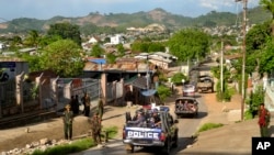 FILE - Army officers stand guard as police officers patrol in Lashio, Myanmar, on May 29, 2013. The country's military regime lost Lashio, the location of its northeast regional command center, on Aug. 3, 2024, to armed resistance groups.