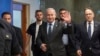 Israeli Prime Minister Benjamin Netanyahu, center, waves to the media as he arrives to the cabinet meeting at the prime minister's office in Jerusalem, July 17, 2023.