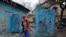 A woman stands next to a house damaged by recent shelling in the course of Russia-Ukraine conflict in Donetsk, Russian-controlled Ukraine, Jan. 7, 2024. 