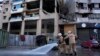 Seorang pekerja pertahanan sipil berlari di depan sebuah bangunan di Israel yang nampaknya sedang diserang untuk membunuh seorang pemimpin politik senior dari kelompok Hamas, yaitu Saleh Arouri, di pinggiran selatan Beirut, ibu kota Lebanon, 3 Januari 2024. (Foto: AP)