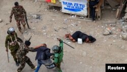 FILE - Riot police accost a supporter of Kenya's opposition leader Raila Odinga during an anti-government protest against the imposition of tax hikes by the government, in Mlolongo settlement of Machakos county, July 12, 2023.