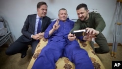 Ukrainian President Volodymyr Zelenskyy, right, and Netherland's caretaker Prime Minister Mark Rutte pose for a photo with a wounded Ukrainian soldier in a hospital in Odesa, Ukraine, on Oct. 13, 2023. (Ukrainian Presidential Press Office via AP)