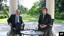 En esta fotografía publicada por la Presidencia de Argentina, el presidente electo Javier Milei, a la derecha, y el presidente de Argentina, Alberto Fernández, posan durante una reunión en la residencia de gobierno, en Buenos Aires, Argentina, el martes 21 de noviembre de 2023.