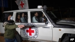 A Red Cross vehicle carrying Israeli hostages drives by at the Gaza Strip crossing into Egypt in Rafah on Nov. 25, 2023.