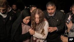 Palestinian activist Ahed Tamimi, center, is supported by her mother after she was released from prison by Israel, in the West Bank town of Ramallah, Nov. 30, 2023. A U.N. report on July 31, 2024, says prisoners and hostages of Israel and Hamas are subjected to mistreatment.