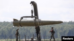 FILE - Russian servicemen equip an Iskander tactical missile system - a dual-capable missile able to carry a conventional or nuclear warhead - outside Moscow, June 17, 2015.