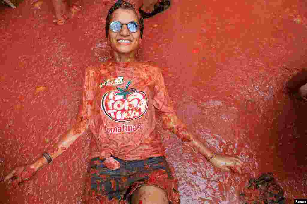 Participante deitada na polpa de tomate durante &ldquo;La Tomatina&rdquo; em Bunol, perto de Valência, Espanha, 28 de agosto de 2024.