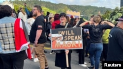 Salah satu warga membawa poster bertuliskan "saya akan berbicara bahasa Maori" dalam aksi unjuk rasa menentang pemerintahan baru di Selandia Baru. Aksi berlangsung di Wellington, pada 5 Desember 2023. (Foto: Reuters/Lucy Craymer)