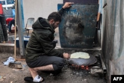 A man prepares traditional unleavened bread on an open fire at school run by the United Nations Relief and Works Agency for Palestine Refugees in the Near East (UNRWA) in Rafah, in the southern Gaza Strip, Nov, 14, 2023.