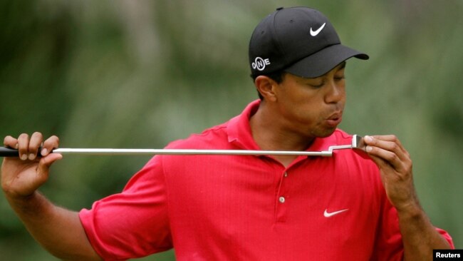 FILE - Tiger Woods blows on his putter on the 10th hole during final round play of the Tournament Players Championship golf tournament at the TPC at Sawgrass in Ponte Vedra, Florida, May 13, 2007.