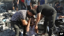 Palestinians comfort a crying man after he lost relatives under the rubble of a destroyed house following an Israeli airstrike in Gaza City, Nov. 4, 2023. 