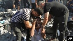 Palestinians comfort a crying man after he lost relatives under the rubble of a destroyed house following an Israeli airstrike in Gaza City, Nov. 4, 2023.