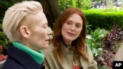 This image released by Sony Pictures Classics shows Julianne Moore, right, and Tilda Swinton in a scene from "The Room Next Door." It's the first full-length film in English for Spain's Pedro Almodovar.