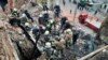 In this photo provided by the Ukrainian Police Press Office, emergency workers search for victims of a Russian rocket attack that damaged a multistory building in central Kharkiv, Oct. 6, 2023.