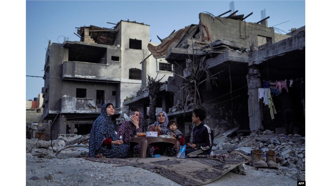 Palestinska porodica Al Nadži na iftaru, usred ruševina njihove porodične kuće, prvog dana muslimanskog svetog meseca posta Ramazana u centralnom pojasu Gaze 11. marta 2024.