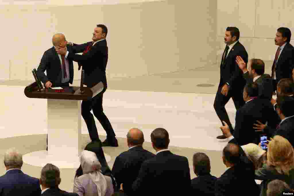 Turkey's AK Party lawmaker Alpay Ozalan scuffles with Workers' Party of Turkey lawmaker Ahmet Sik, who was speaking about jailed opposition lawmaker Can Atalay's return to the assembly, in Ankara, Turkey.